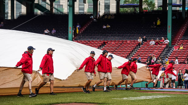 Jun 14, 2023; Boston, Massachusetts, USA; The Boston Red Sox field crew cover the field in anticipation of rain before the start of the game against the Colorado Rockies at Fenway Park.